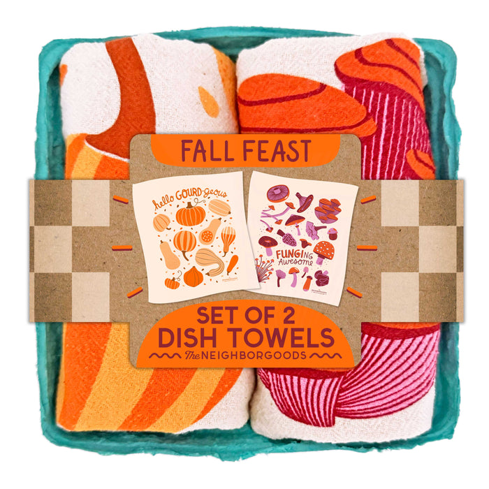 Two cotton dish towels—one with orange gourds, one with mushrooms—come rolled in a teal box labeled “Dish Towel Set of 2 - Fall Feast” by The Neighborgoods. Colorful, gift-ready kitchen towels for any occasion!.