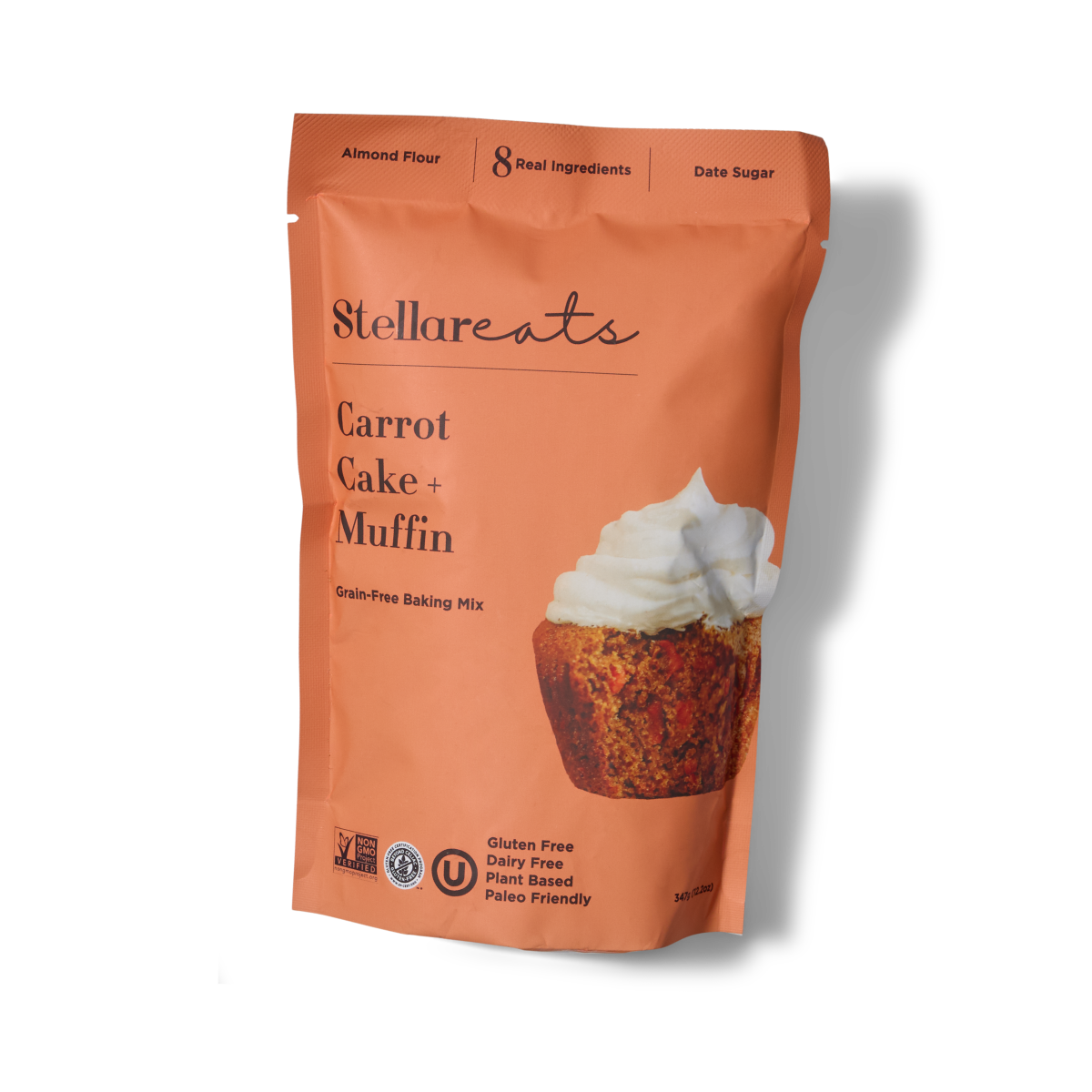 An orange package of Stellar Eats Carrot Cake + Muffin grain-free baking mix, featuring a photo of a muffin topped with white icing. The packaging highlights it as gluten free, dairy free, plant based, and paleo friendly.