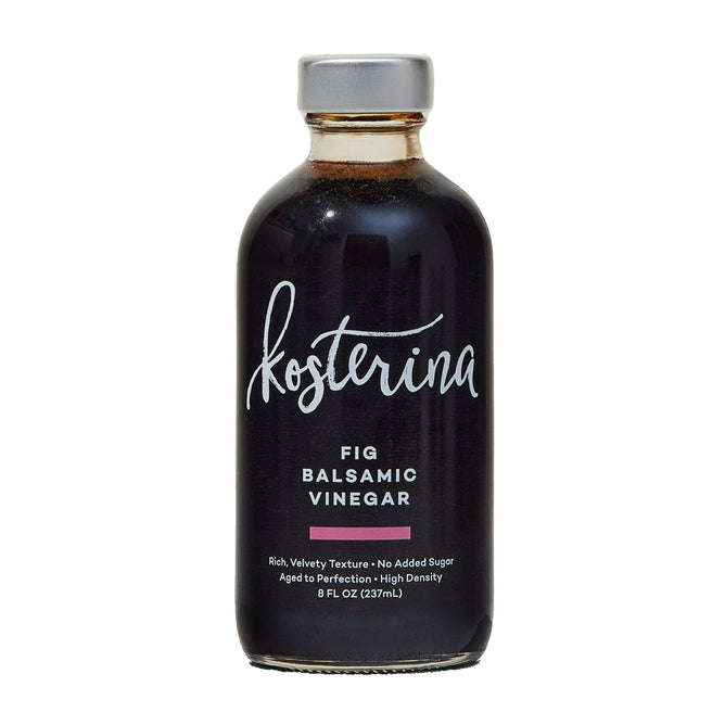 A glass bottle of Kosterina Fig Balsamic Vinegar with a silver cap and white and pink label text contains 8 fl oz (237 ml) of barrel-aged, rich dark vinegar from Modena, Italy.