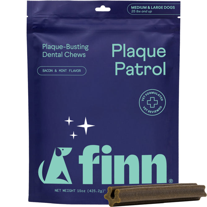 A blue bag of Finn Plaque Patrol dental chews for medium and large dogs, bacon and mint flavor. The packaging features a dog graphic and text about plaque-busting dental chews. One chew is placed in front of the bag.