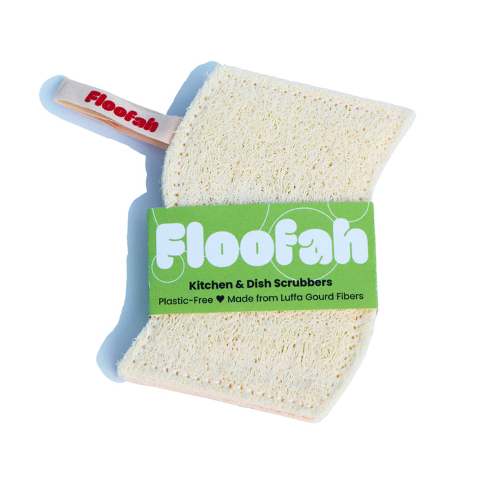 Introducing the Floofah Luffa Fiber Kitchen Sponge—a rectangular, plant-based dish scrubber with green packaging and a small pink handle. This biodegradable cleaning sponge is made from luffa gourd fibers and comes with a tag that reads "Plastic-Free, Made from Luffa Gourd Fibers." Enjoy an eco-friendly clean with this sustainable kitchen essential.