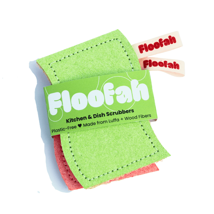 Two stacked, rectangular Floofah Luffa + Wood Dual Kitchen & Dish sponges with green and red abrasive sides, secured by a paper wrapper identifying them as plastic-free plant fiber sponges made from luffa and wood fibers.