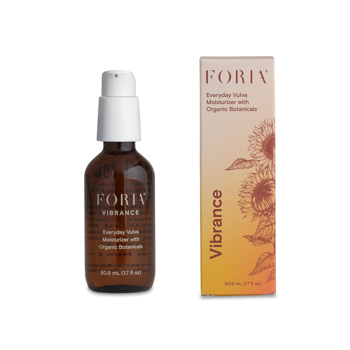 A brown bottle labeled Foria Vibrance Everyday Vulva Moisturizer with Organic Botanicals, featuring pumpkin seed oil, stands beside its sunflower-adorned box, highlighting this all-natural hydration product.