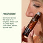 A person rolls Plant Therapy Facial Oil Roll-On - Wrinkle Eraser onto their cheek, enjoying its hydrating and anti-aging benefits. The text explains how to use the product: gently roll it onto the face or targeted areas such as under-eyes, crow’s feet, eleven lines, and smile lines for ultimate nourishment.