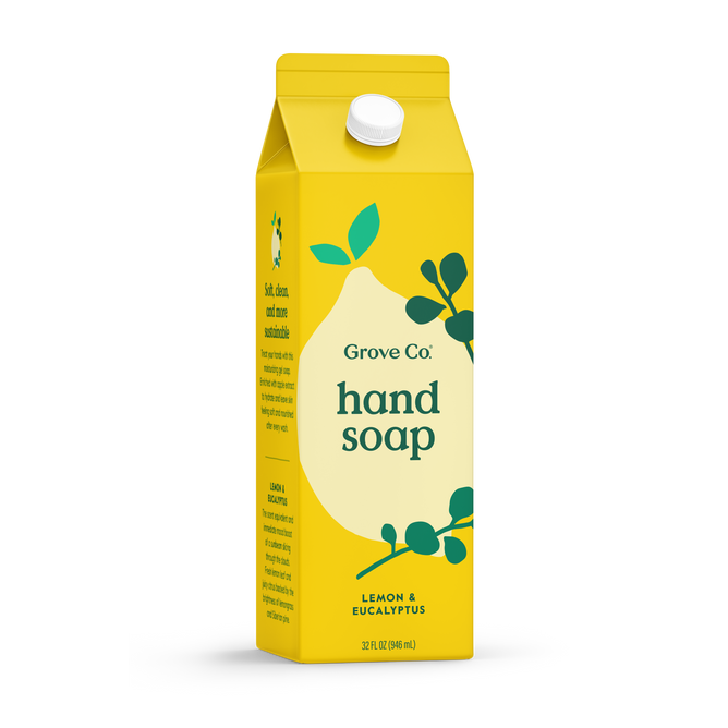 A yellow carton labeled Grove Collaborative features Grove Co. Hand Soap – Hydrates & Moisturizes With Every Wash, scented with lemon and eucalyptus. The milk carton-style package with green leaves and white text is a recyclable soap refill.