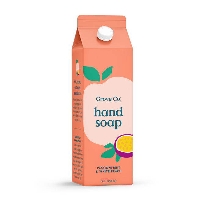 A juice box-shaped coral carton, labeled Grove Collaborative Grove Co. Hand Soap – Hydrates & Moisturizes With Every Wash in passionfruit & white peach, features fruit art, a white cap, and offers a fresh, natural scent.