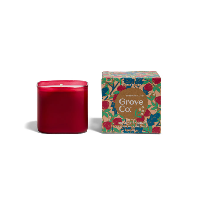 A limited edition Grove Co. Candles 9.5oz - Fall Collection candle sits by its box, which displays a floral and fruit design and reads Wild Currant & Oak, highlighting sustainable, eco-friendly choices for your home.