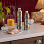 Two Grove Co. Laundry Sheets - Fall Collection rest on a white countertop beside a candle, mini pumpkins, a leaf, and a Grove Co. box. Warm autumn decor adds to the cozy scene with pre-measured sheets for odor elimination.