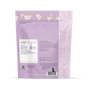 A lavender resealable pouch with white and gold bunting contains grab green Baby Laundry Detergent Pods (5+ Months). The back features usage instructions, transparency details, company info, and a dog and cat silhouette at the bottom.