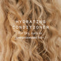 Close-up of long, blonde, curly hair with overlaid text: Hydrating Conditioner Bar by Good Juju Body & Home. Ideal for frizzy or dry, overprocessed curls—this organic bar leaves hair looking healthy and moisturized.