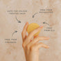 A hand holds the Good Juju Body & Home Hydrating Conditioner Bar. Text reads: Safe for colour treated hair, phthalate-free, SLS-free, paraben-free. Great for frizzy hair and works well with their organic shampoo bar. Marble background.