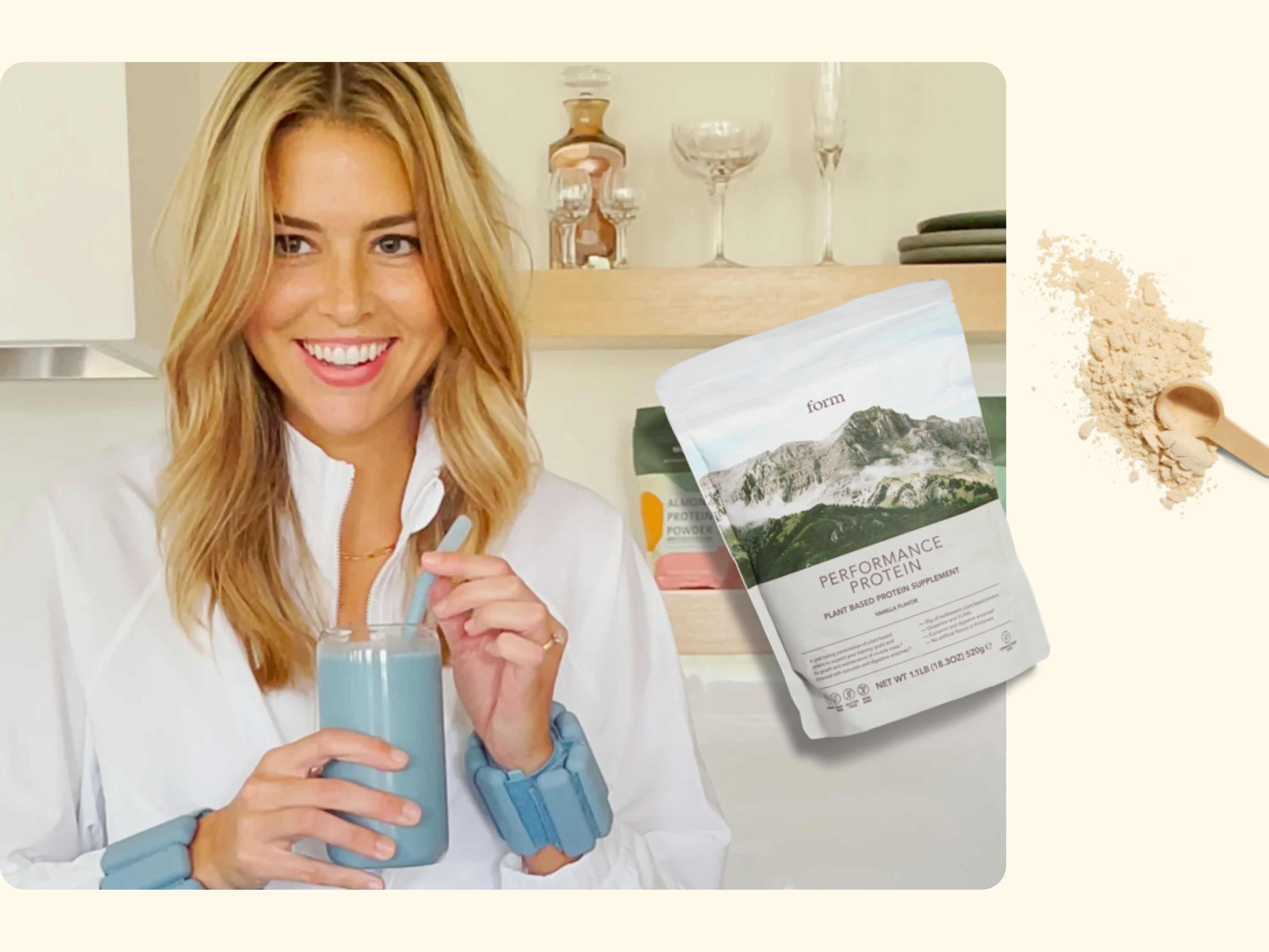 A smiling woman in a white shirt holds a spoon and a glass with a blue drink. Next to her is a bag labeled Performance Protein and a wooden spoon with protein powder on a pale background.