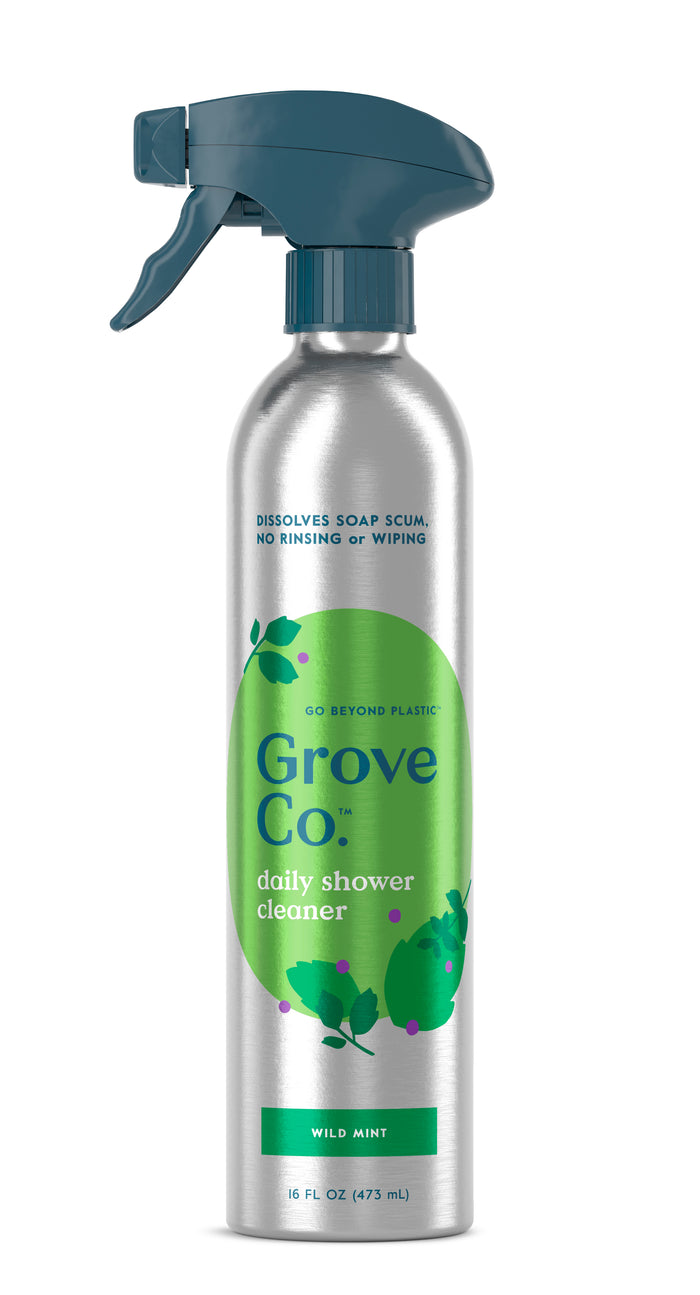 The Grove Co. Daily Shower Cleaner comes in a silver aluminum bottle with green leaf graphics and a dark teal nozzle, featuring a refreshing wild mint scent. This plant-based formula requires no rinsing or wiping and offers an environmentally friendly option.