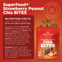 An image of Navitas Organics Superfood+ Strawberry Peanut Chia BITES packaging shows nutrition facts, ingredients, and pictures of the organic peanut butter bites, strawberries, and peanuts on a vibrant red background.