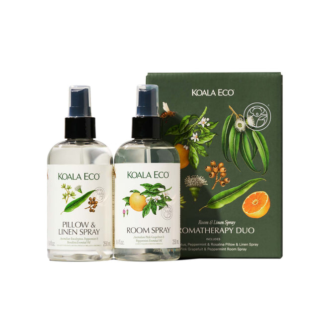 Two Koala Eco Aromatherapy Duo sprays—Pillow & Linen and Room Spray—are displayed next to a green, botanically illustrated Koala Eco Aromatherapy Duo box, emphasizing their fragrant, plant-based ingredients.