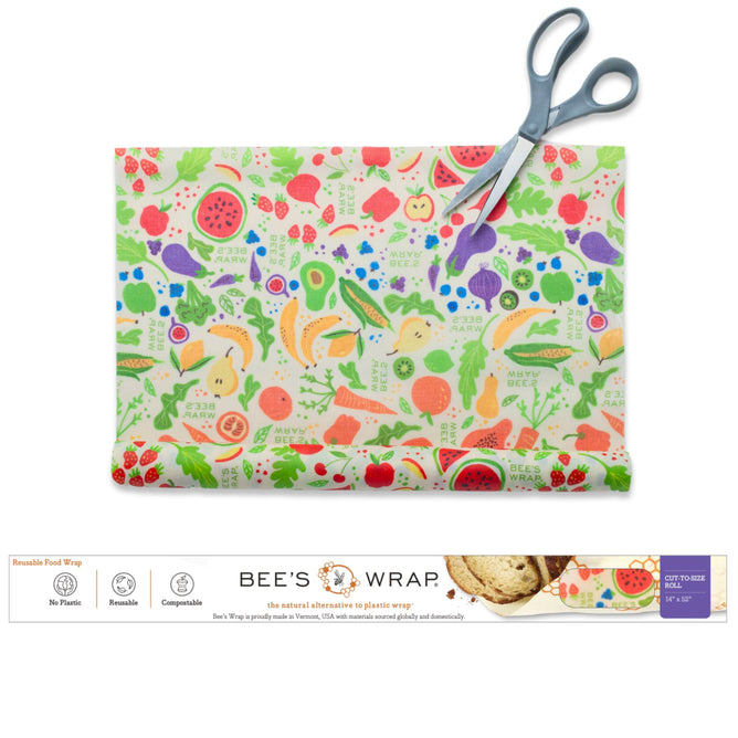 A vibrant, food-themed Beeswax Wraps for Food - Cut to Size Roll by Bee's Wrap is shown being trimmed with scissors, with the packaging displayed below. The label emphasizes its main features: no plastic, reusable, and compostable—making it an eco-friendly and customizable alternative to traditional plastic wrap in the kitchen.