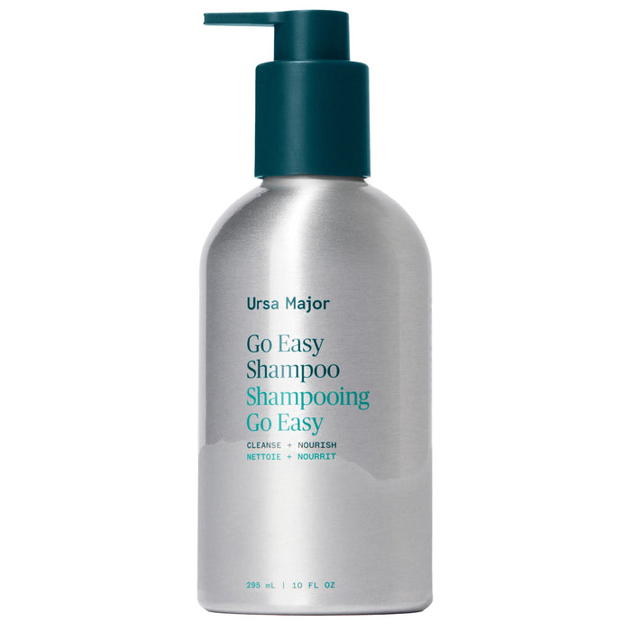 A silver pump bottle of Ursa Major Go Easy Shampoo, featuring teal label text and pump, stands upright against a white background. This shampoo is sulfate-free and suitable for all hair types.