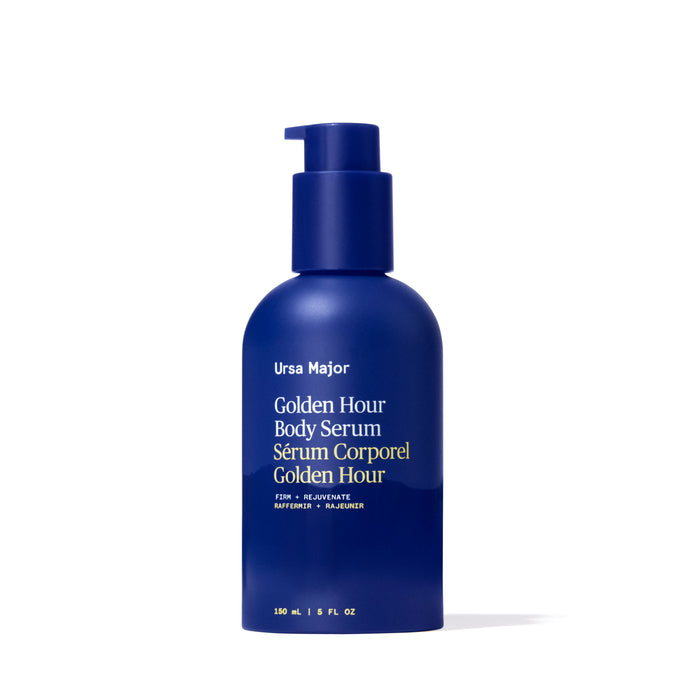 A blue pump bottle of Ursa Major Golden Hour Body Serum with white and gold text in English and French. This 150 ml (5 fl oz) skin treatment hydrates and rejuvenates for a youthful glow.