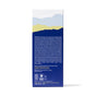 The back of the Ursa Major Golden Hour Body Serum box features a blue, yellow, and light blue mountain design at the top, white text listing rejuvenating serum ingredients, and certification plus recycling symbols at the bottom.