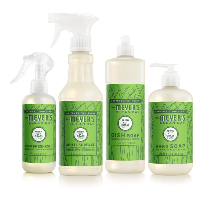 Four Mrs. Meyer’s Endless Summer Cleaning Set products with green labels—dish soap, multi-surface cleaner, hand soap, and room freshener—stand side by side in the limited edition Fresh Cut Grass scent.
