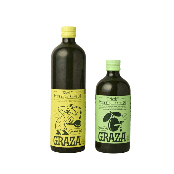 The Graza Olive Oil Starter Set - Glass includes two dark green bottles: the larger, with a yellow cap and label featuring cooking illustrations, is for cooking; the smaller has a green cap and olive branch label for finishing.
