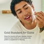 A person uses the Great Gums Brush by COCOLAB and smiles. Text: Gold Standard for Gums—ideal for gum disease, braces, implants, sensitive gums, fixed retainers, or as a supplement to traditional flossing.