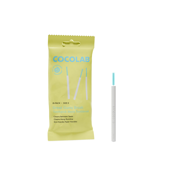 A yellow-green COCOLAB Great Gums Brush package is shown beside a white-handled interdental brush with blue bristles, designed for gentle between-teeth cleaning and everyday care for sensitive gums.