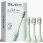 SURI’s 3x Brush Replacement Heads, shown with a light green plant-based toothbrush in Winter Fern—ideal for sensitive teeth and gums. Box features: “Up to 5x more plaque removed.” All heads are recyclable. Brand: SURI.