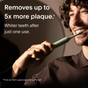 A man smiles while brushing with a SURI electric toothbrush using 3x SURI Brush Replacement Heads. Text reads: Removes up to 5x more plaque. Whiter teeth after just one use.*Than an ADA-approved manual brush.