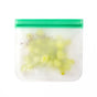 The (re)zip Flat Sandwich Bag is a reusable, semi-transparent silicone zip bag with a green closure—a stylish, sustainable, leakproof alternative to PEVA bags, ideal for packing green grapes or lunches.