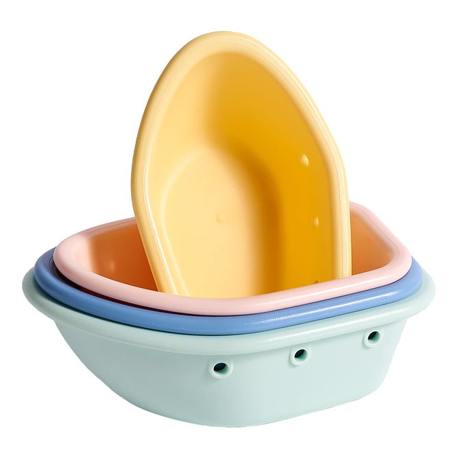The Sprout Ware® Floating Boats by Green Sprouts are a charming set of four pastel-colored oval bowls made from plant-based plastic. These non-toxic bath toys in yellow, pink, blue, and mint green come with drainage holes. The smallest yellow boat floats gracefully atop the stack.