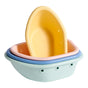 The Sprout Ware® Floating Boats by Green Sprouts are a charming set of four pastel-colored oval bowls made from plant-based plastic. These non-toxic bath toys in yellow, pink, blue, and mint green come with drainage holes. The smallest yellow boat floats gracefully atop the stack.