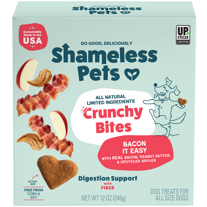 A box of Shameless Pets Bacon it Easy Crunchy Bites, all-natural dog treats with bacon, upcycled apple, and peanut butter, featuring a playful dog illustration on a teal background.