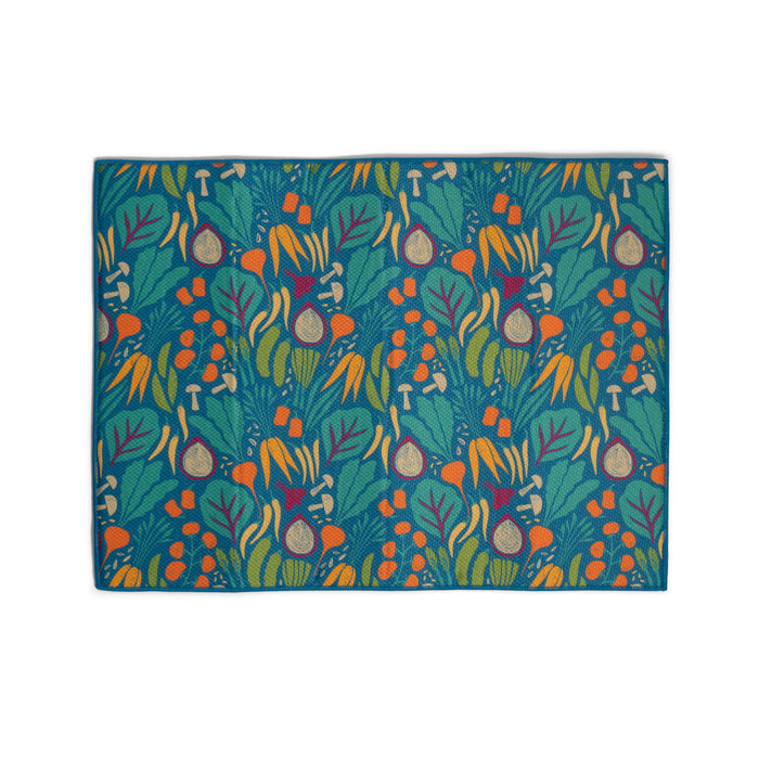 The Grove Co. Dish Drying Mat features a vibrant botanical pattern with leaves, orange berries, and purple figs on blue. Made from recycled polyester microfiber, it adds a lively, nature-inspired touch to your kitchen.
