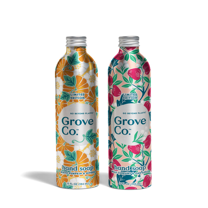The Grove Co. Hand Soap Set - Fall Collection features two eco-friendly metal bottles in Spiced Pumpkin & Ginger and Wild Currant & Oolong, with vibrant floral designs as part of this sustainable, limited edition release.