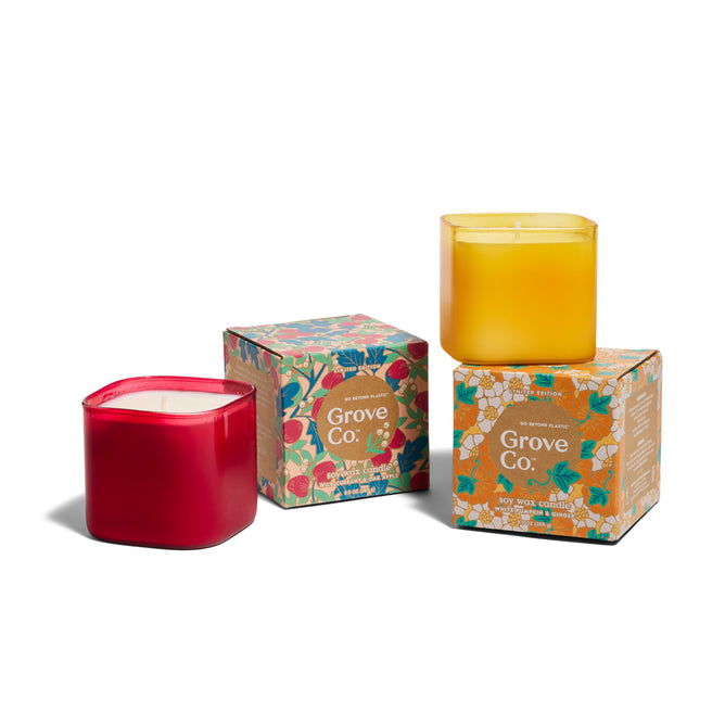 The Grove Co. Candle Set - Fall Collection features two eco-friendly square candles, one red and one yellow, with decorative boxes adorned in colorful floral designs—perfect for adding seasonal charm to your home.