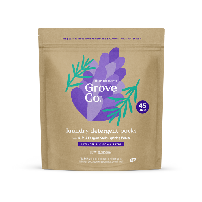 A brown resealable pouch of Grove Co. Laundry Detergent Packs, 45 count, featuring a purple hand design with green leaves, lavender blossom + thyme scent, and packaging that is renewable and compostable.