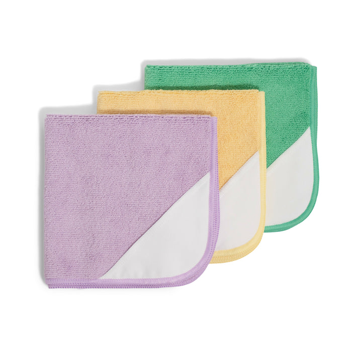 The Grove Co. Microfiber Cleaning Cloths (Set of 3) in purple, yellow, and green feature white triangular corners and are neatly stacked with overlapping edges against a white background.
