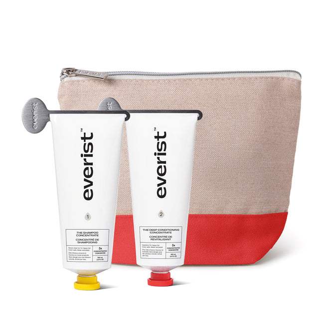 Two Everist tubes from The Haircare Meets Skincare Set stand in front of a beige and red zippered pouch, showcasing Everist’s innovative formulas and bond repair technology for healthier hair.