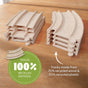 Two stacks of straight and curved toy train tracks rest on wood. A green label reads “Tracks 100% recycled material.” From HABA, the Cars Expansion Set made from 100% Recycled Materials is perfect for toddlers aged 2+.