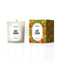 A lit Homesick Hot Cider Candle, made from natural soy wax in a frosted glass jar, sits beside its colorful box decorated with red apples, green leaves, and matching labels.