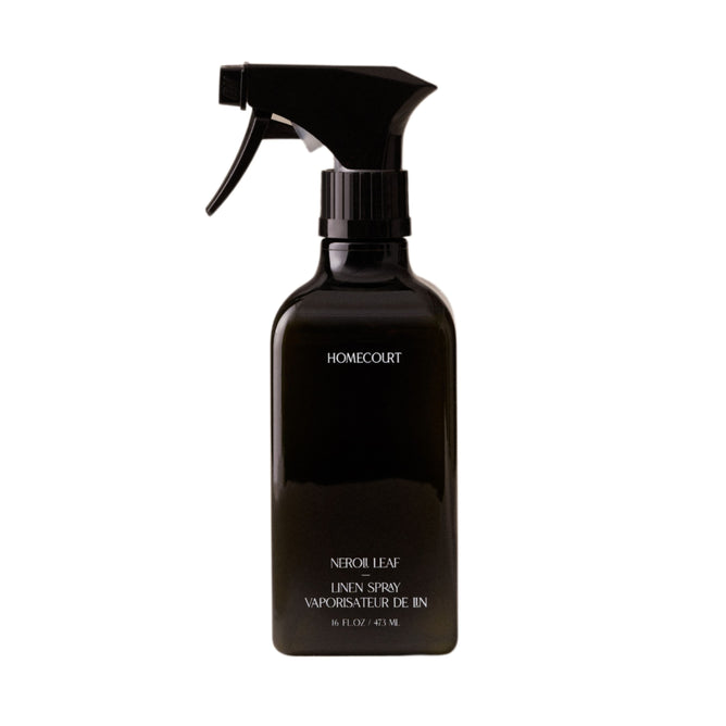 A black spray bottle labeled Homecourt Linen Spray, made with eco-friendly ingredients and their signature Neroli Leaf scent, contains 15 fl. oz. (473 mL) and is shown against a white background.
