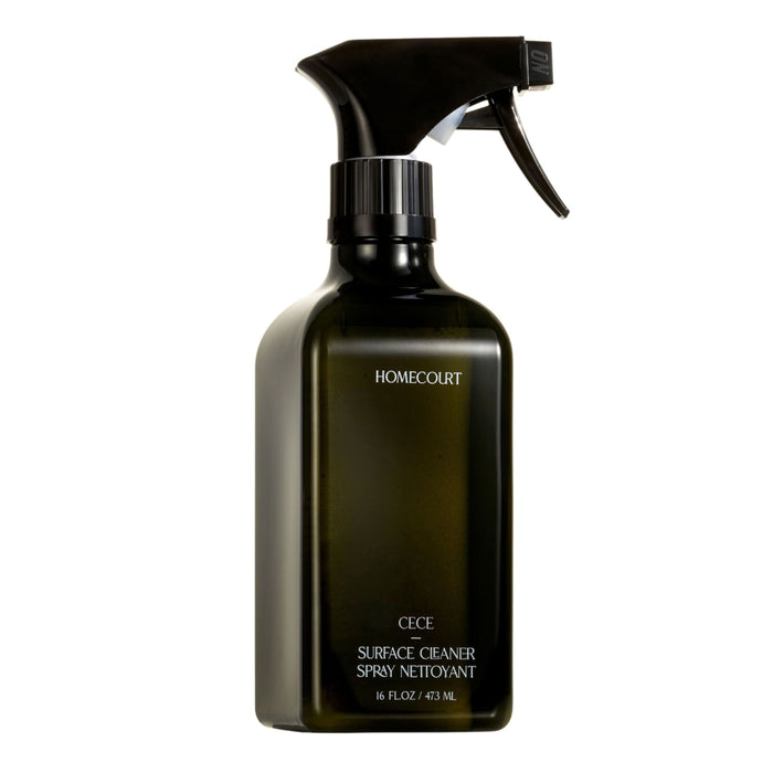 A black spray bottle labeled Homecourt Surface Cleaner, 16 fl. oz. / 473 ml, with fine fragrance and skin-safe ingredients, is shown against a white background.