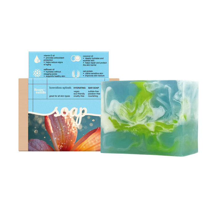 A vibrant Soapymania Hawaiian Splash Hydrating Bar Soap with blue, white, and green swirls is shown in front of its box featuring a plumeria flower and product details for all skin types.
