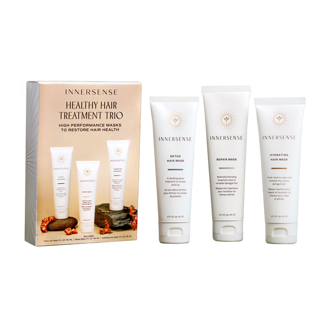 A box labeled Healthy Hair Treatment Trio by Innersense Organic Beauty sits beside three white tubes—Detox Hair Mask, Repair Mask, and Hydrating Hair Mask—each crafted to restore and revitalize your hair’s health.