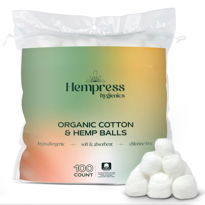 A semi-transparent bag labeled Hempress Hygienics Hemp & Cotton Balls contains 100 sustainable cotton balls, with several hemp fiber cotton balls displayed in front of the package.