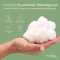 A hand holds a pile of Hempress Hygienics Hemp & Cotton Balls against a green background with icons and text highlighting their sustainable, dermatologist-approved, toxin-free, and non-irritating qualities.