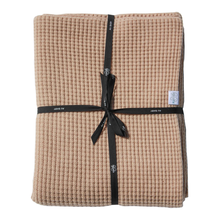 Tan, temperature-regulating Adult Popcorn Blanket - Henna waffle-knit blanket folded and tied with a black ribbon.