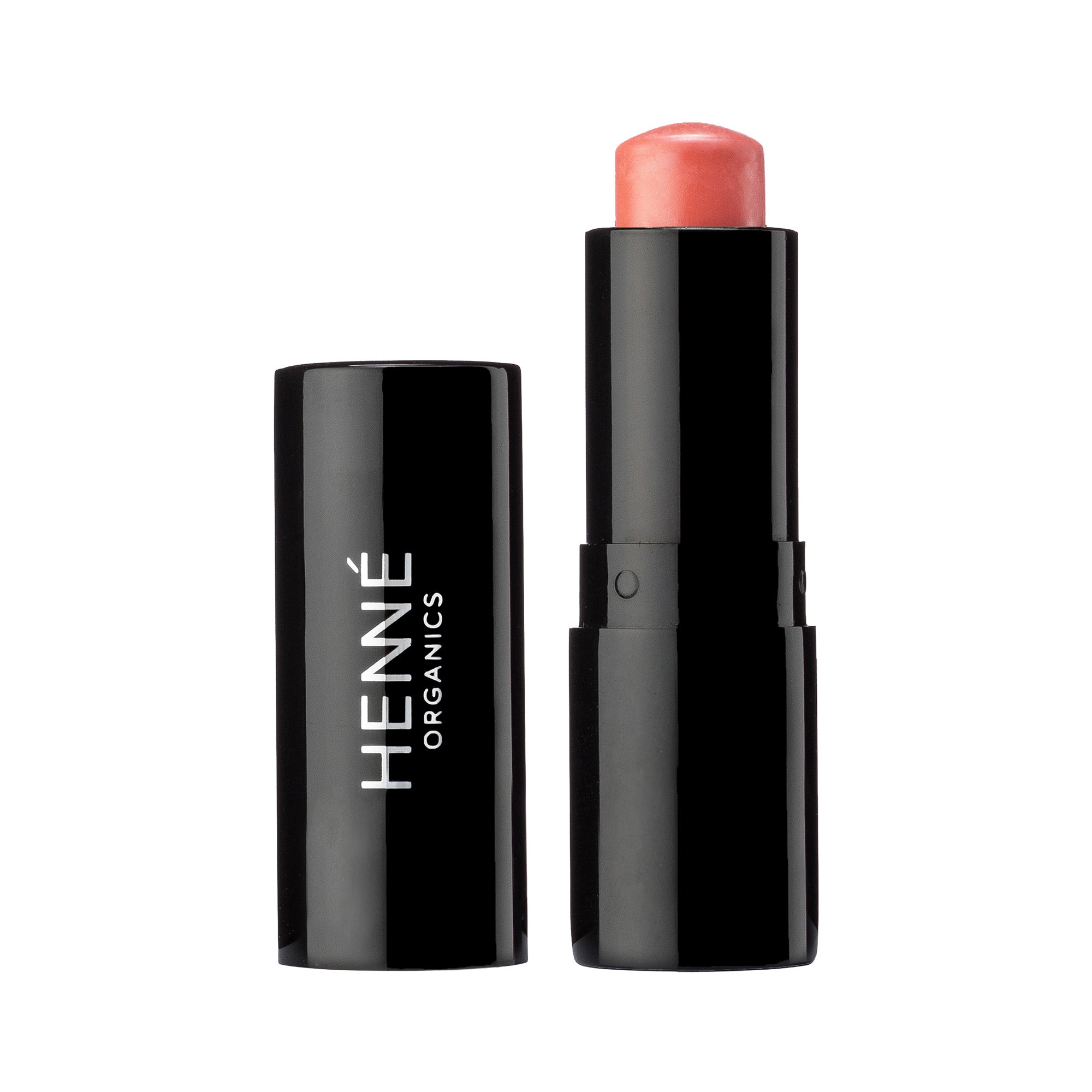 A black Henne Organics Luxury Lip Tint tube, with the cap off, reveals a hydrating pinkish coral lip color and product name on the side.