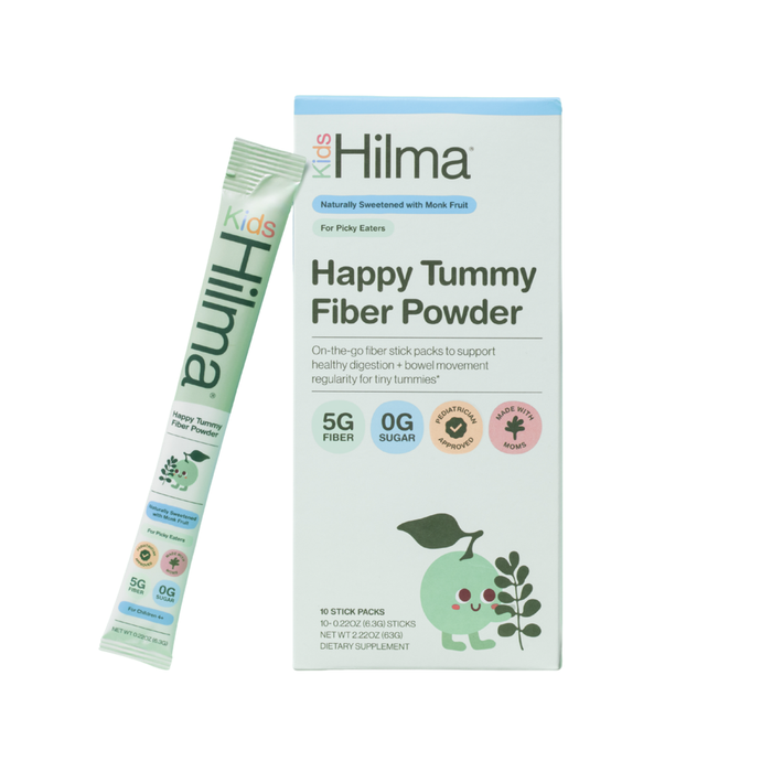 A box and stick pack of Hilma Kids Happy Tummy Fiber Powder Packets, a 5g fiber, 0g sugar kids supplement in playful light blue and green packaging with child-friendly designs and illustrations of a child, leaves, and benefits.
